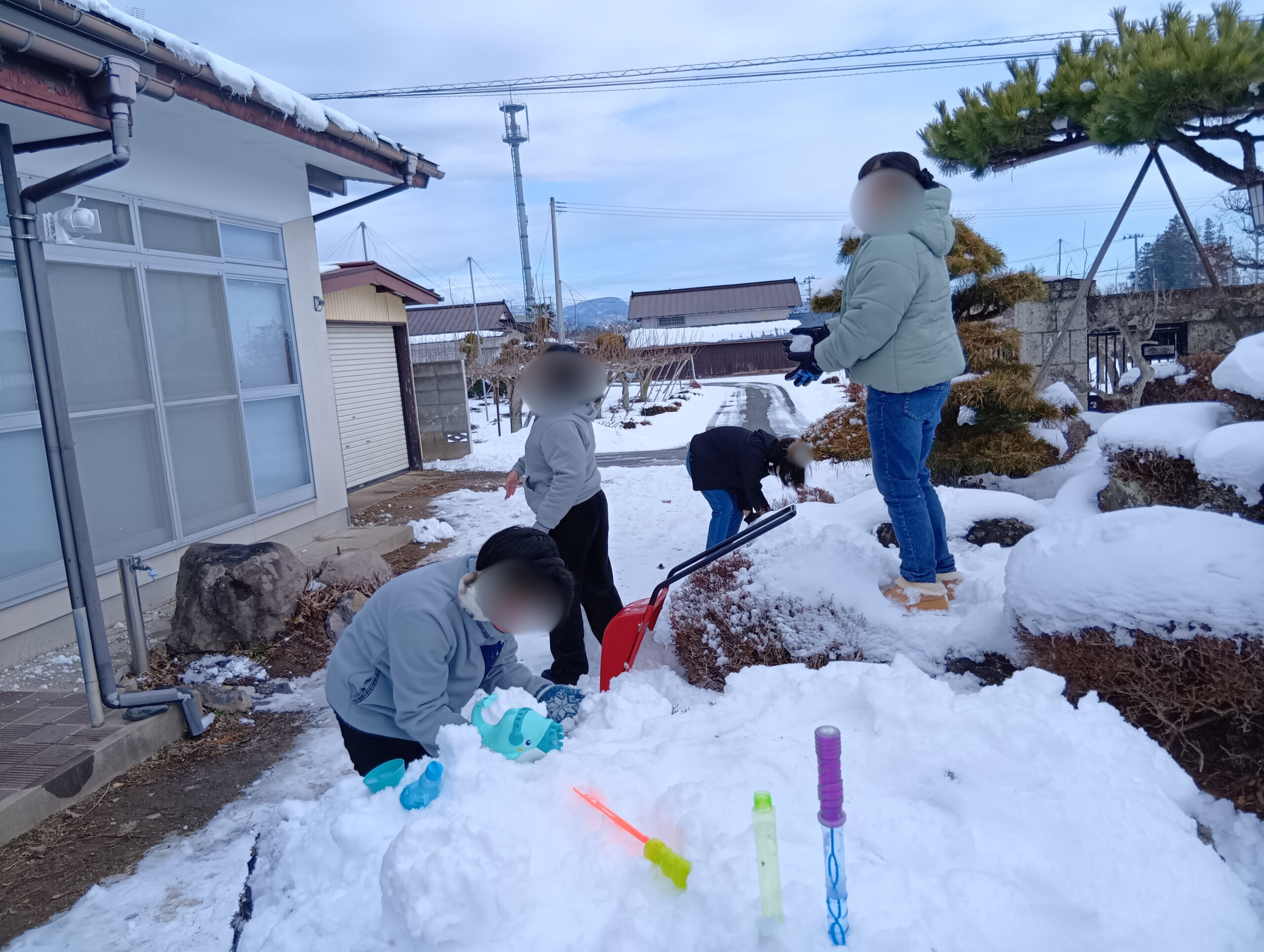 雪の積もった道で遊ぶ子どもたち
