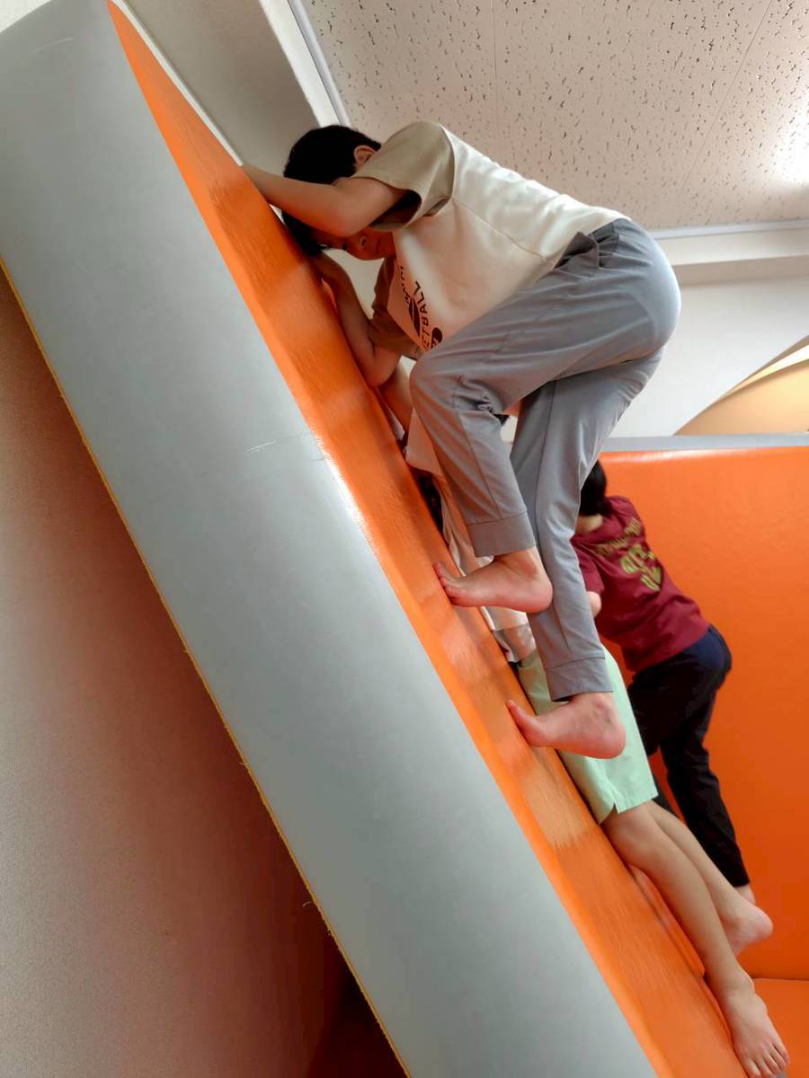 室内の滑り台で遊ぶ子ども