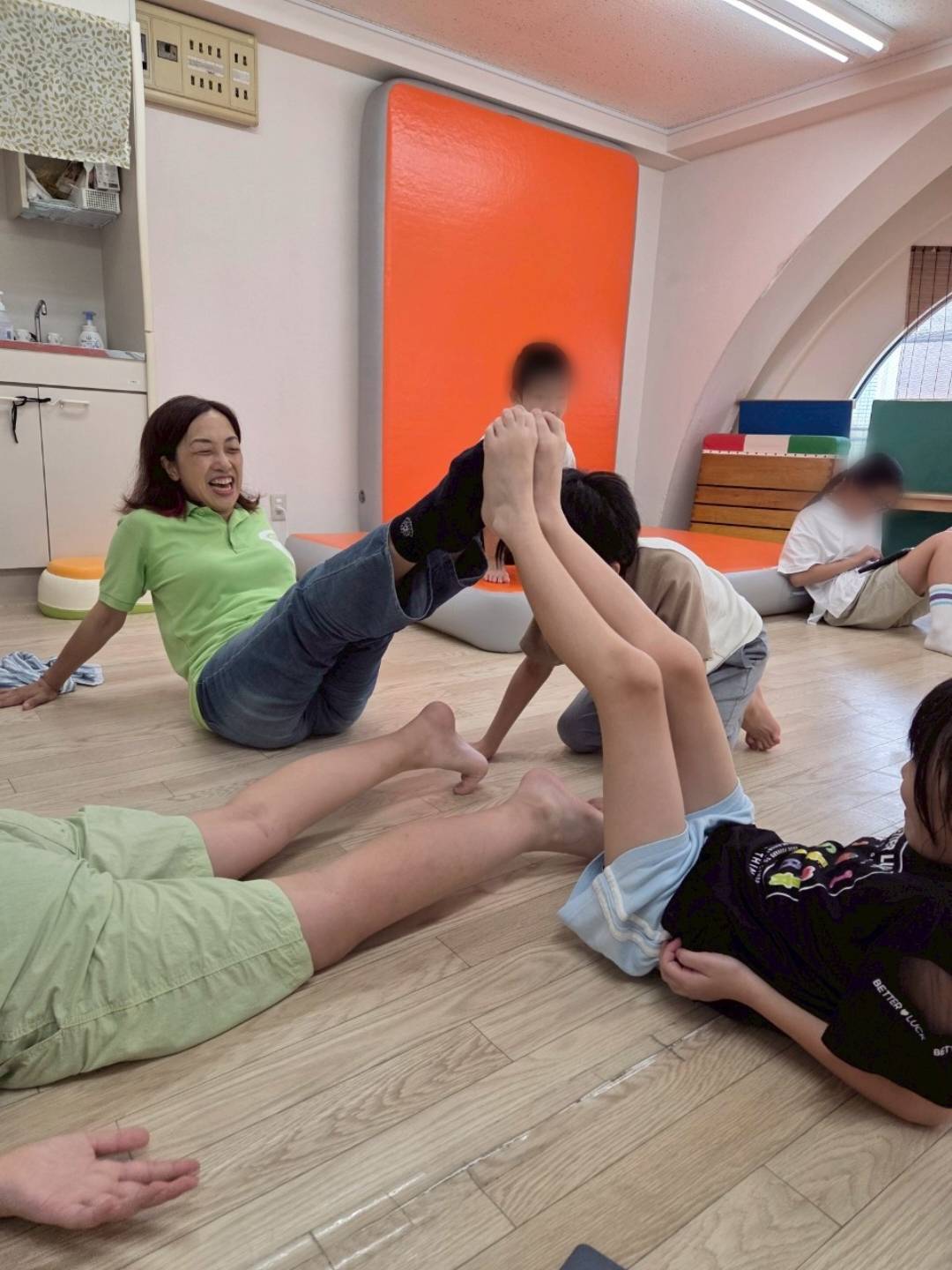室内で体をほぐす子どもと大人