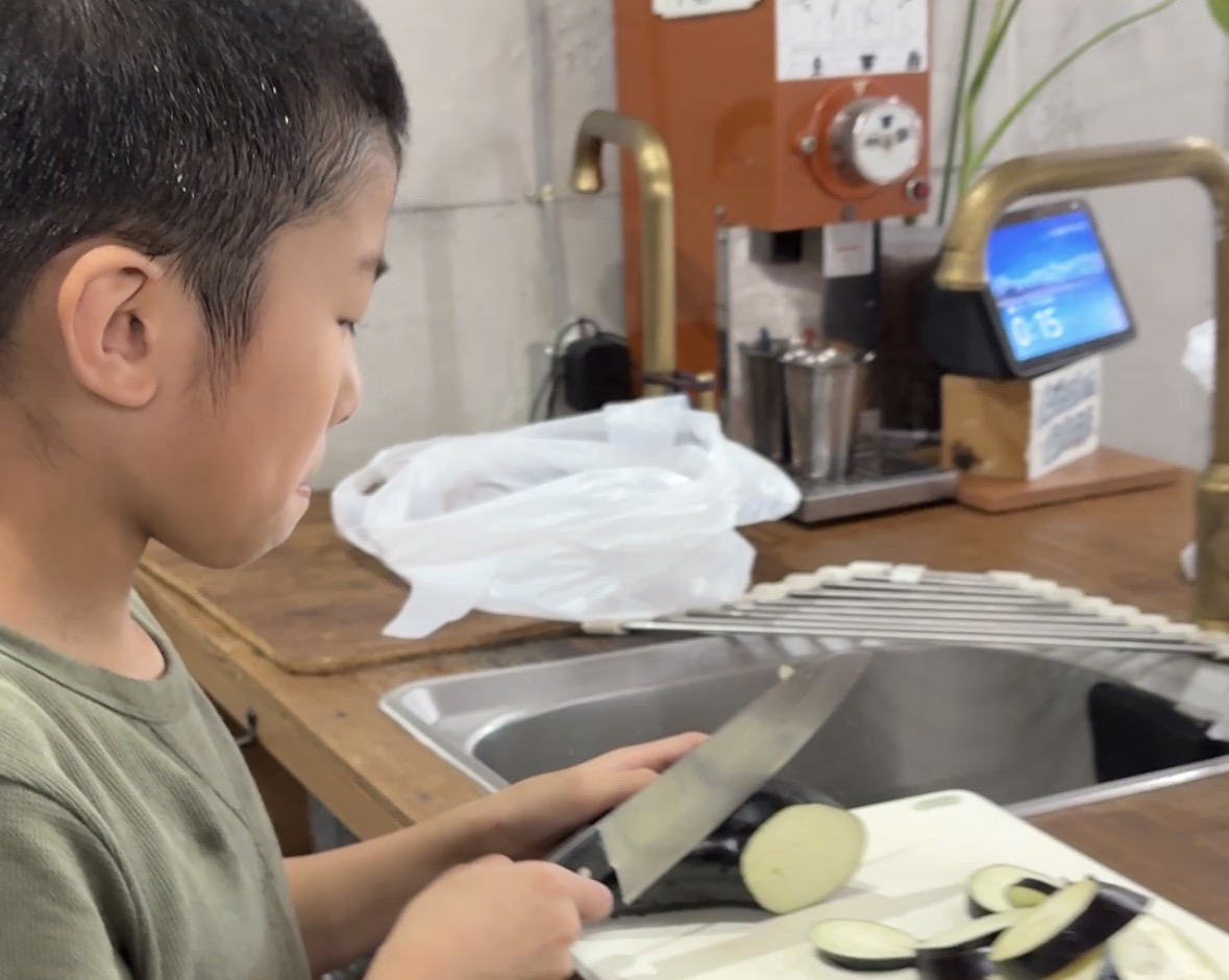 台所で洗いものをする子ども