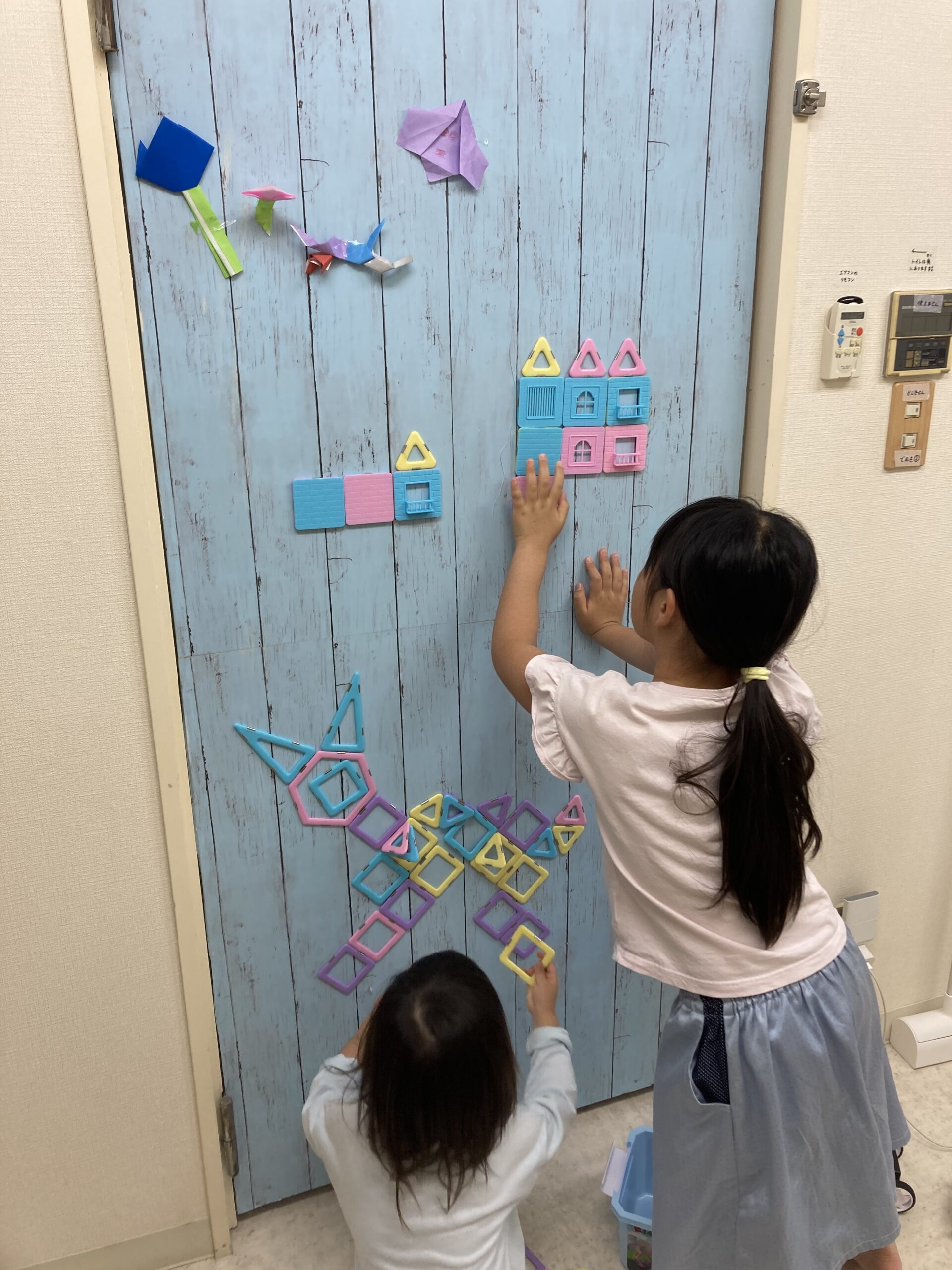 壁に飾りつけをする子どもたち
