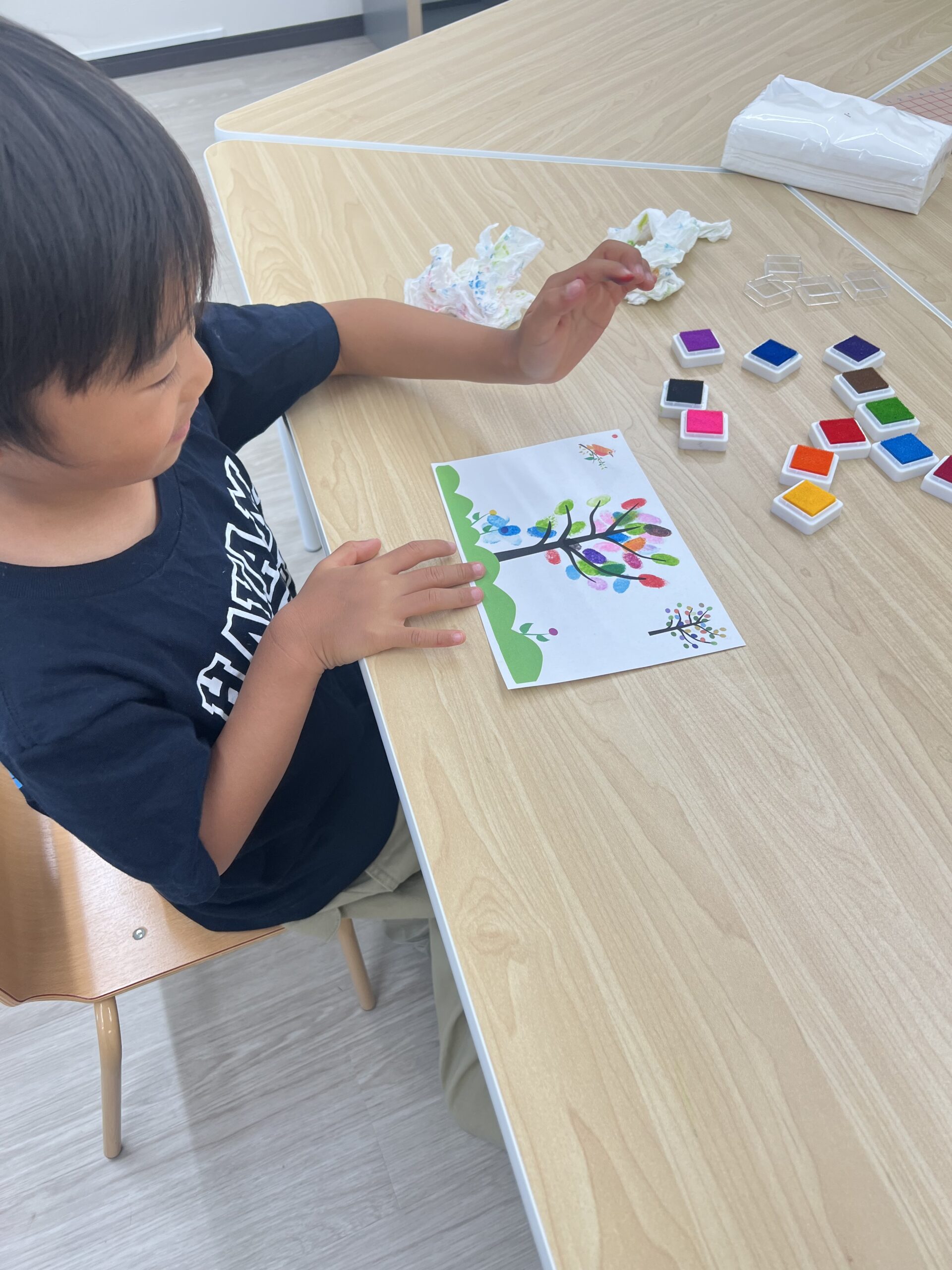 机に向かってカードゲームに取り組む子ども
