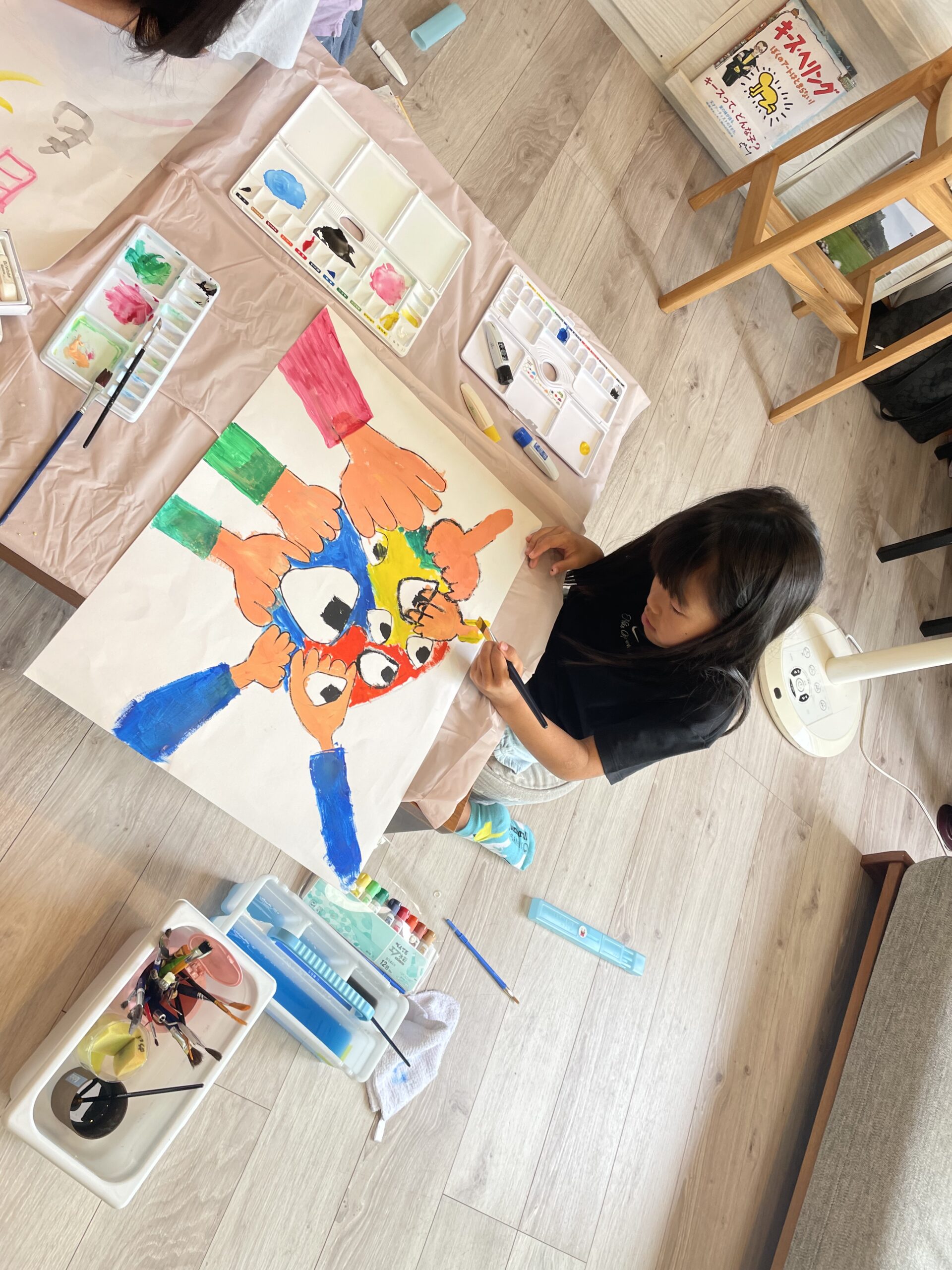 広げた紙に絵を描く様子