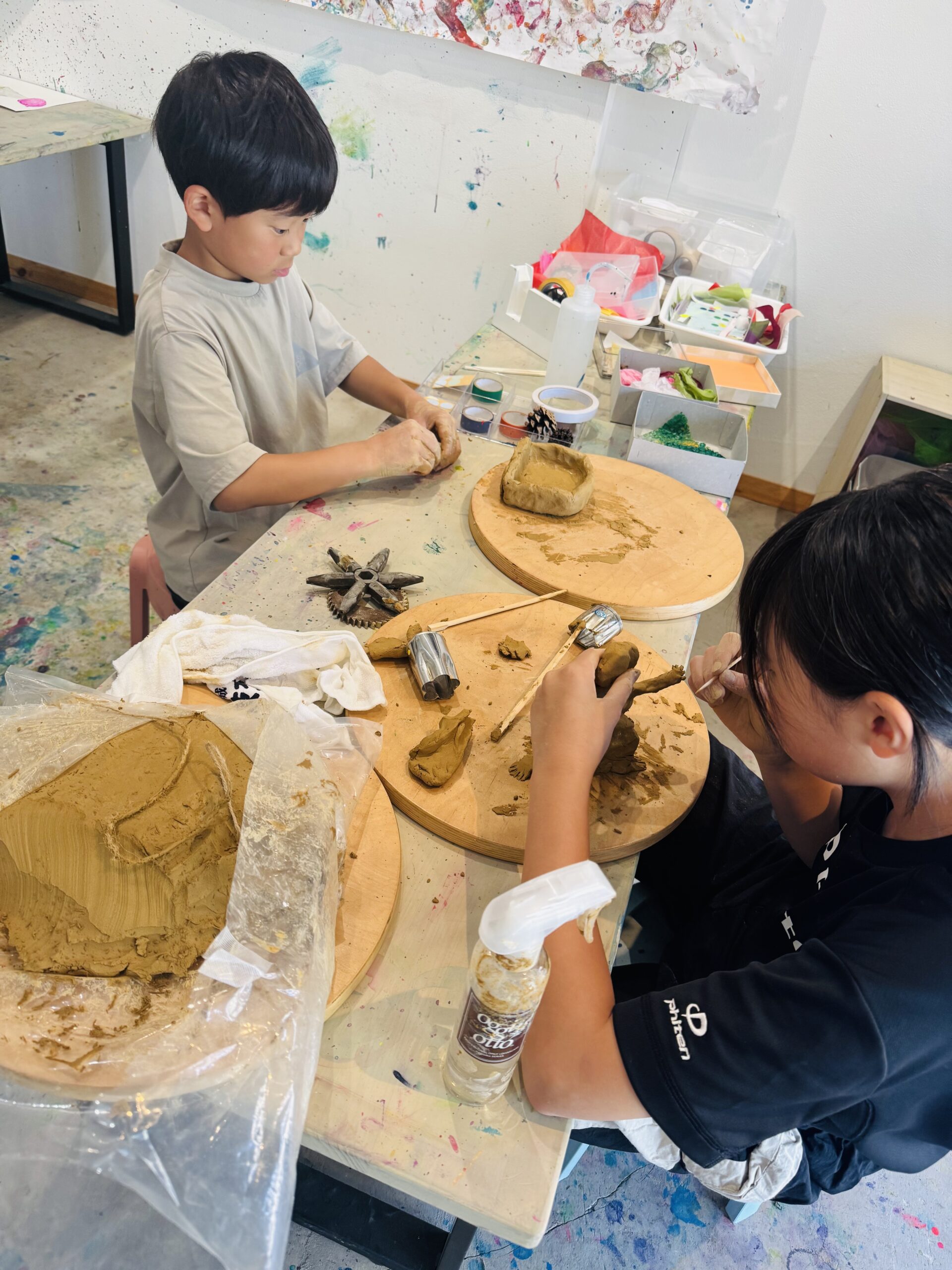 粘土をこねて形をつくる子どもたち