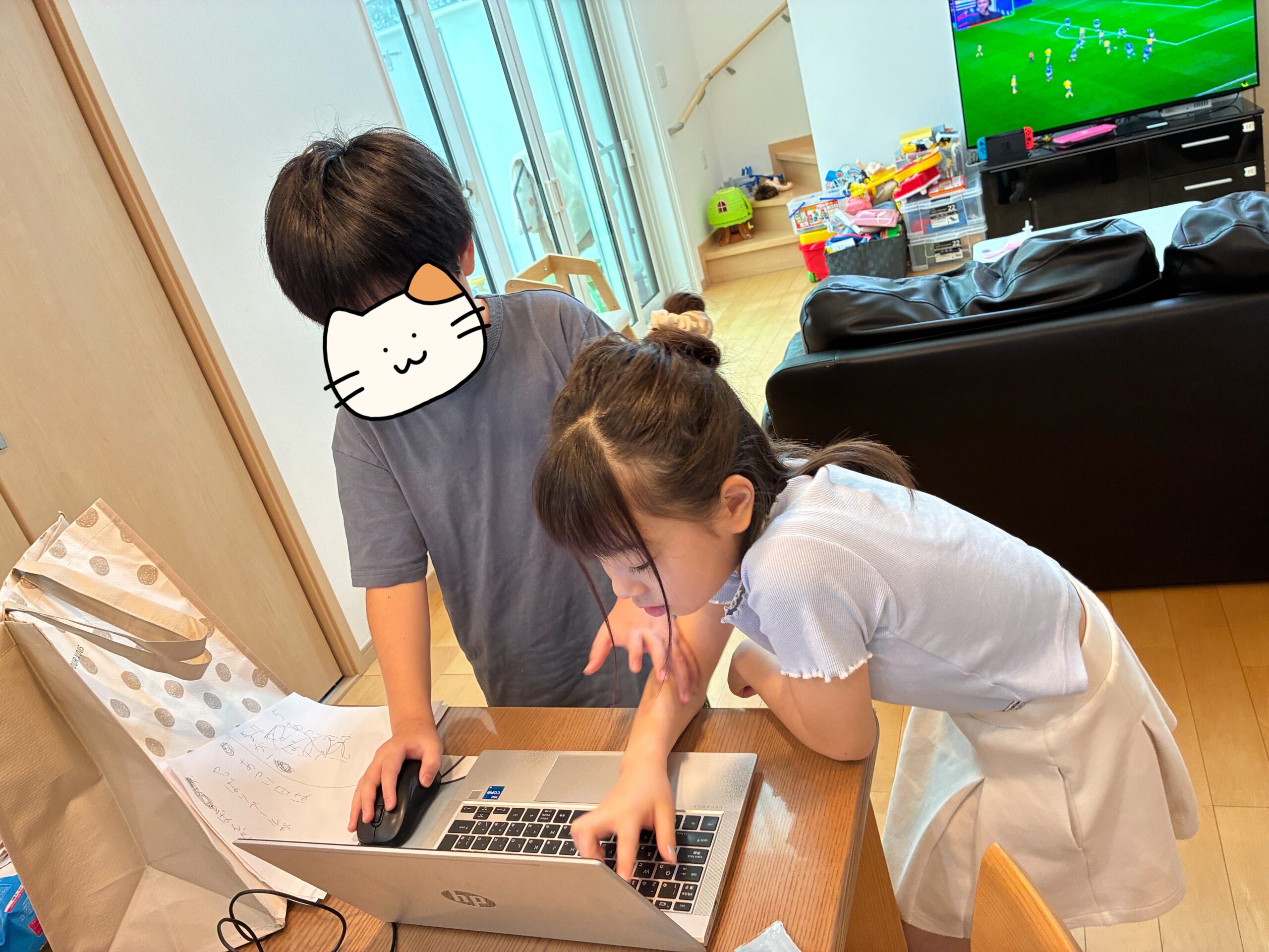ノートパソコンを一緒に見ながら学ぶ子どもたち