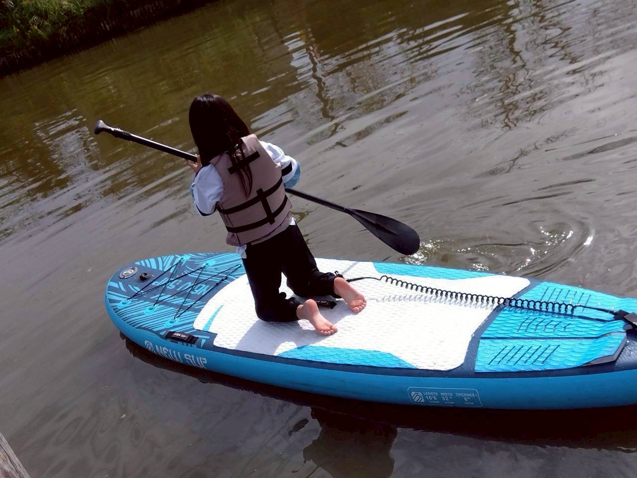 水の上でボードに乗る子ども