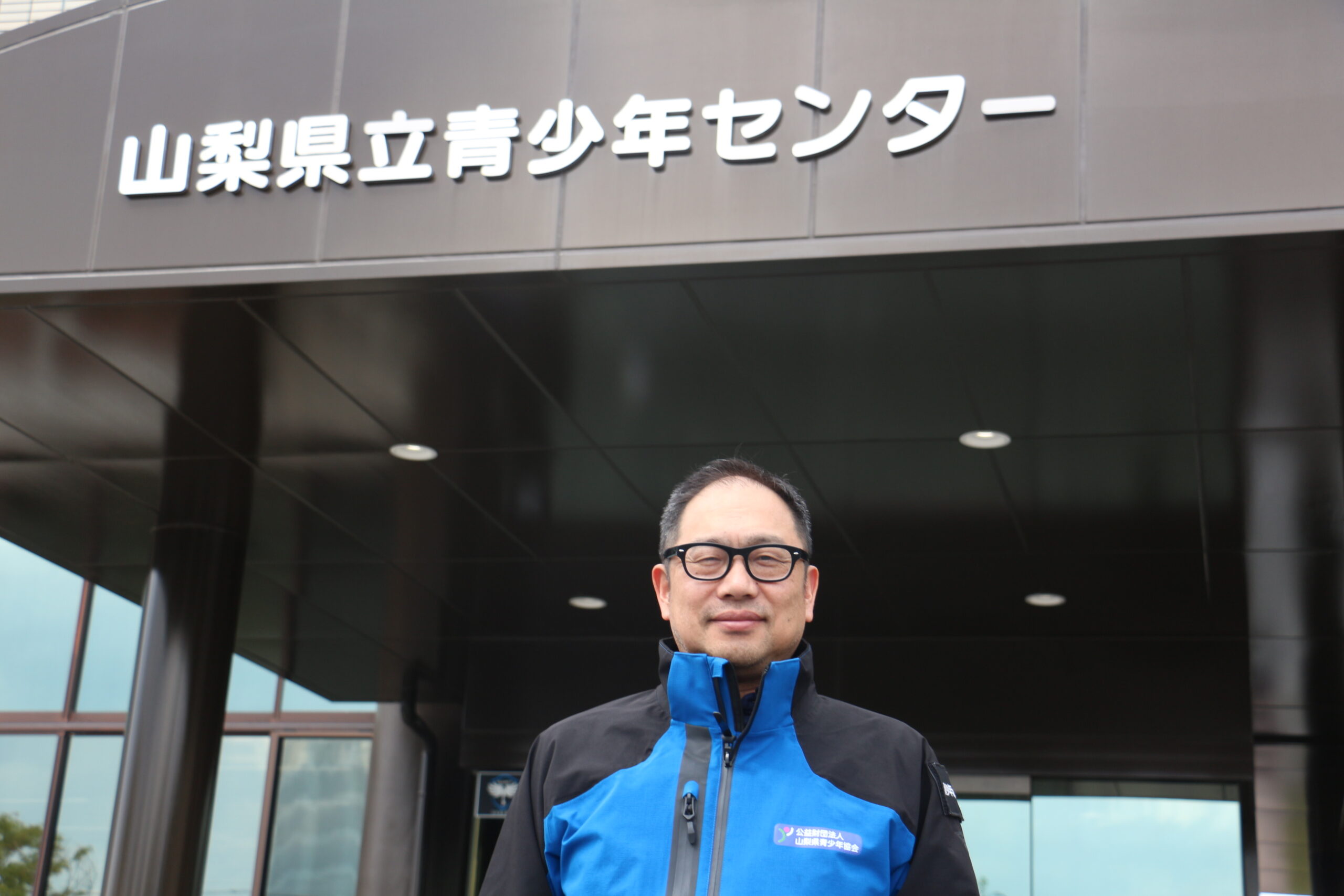 青少年センターの前で立っている依田先生