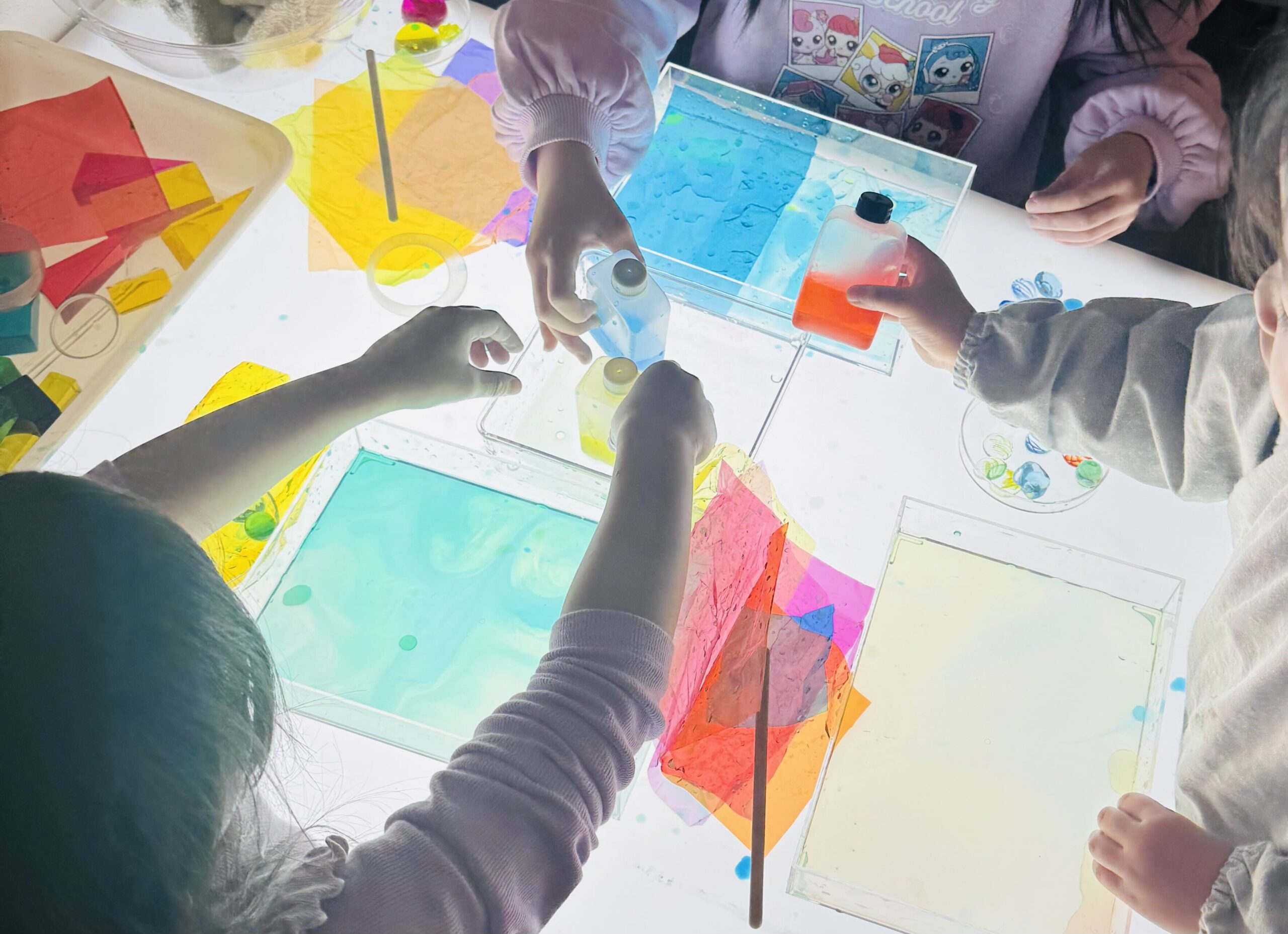 色画用紙を使って工作する子どもたちの手元