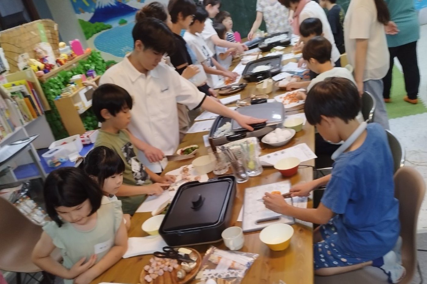 テーブルを囲んで作業する子どもたち