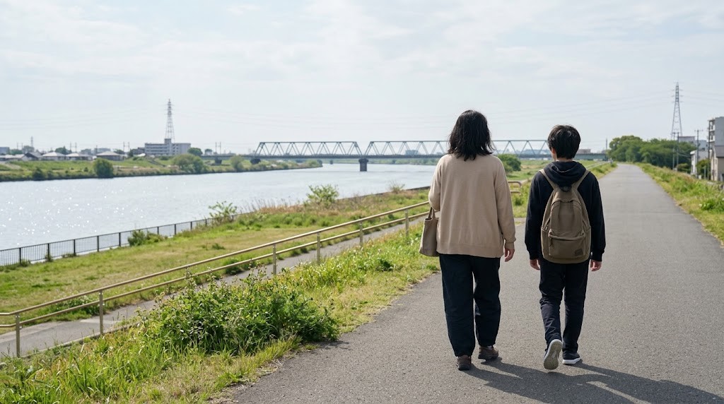 加古川の川沿いを不登校の中学生と保護者が並んで歩き、フリースクールの見学へ向かう場面（イメージ）