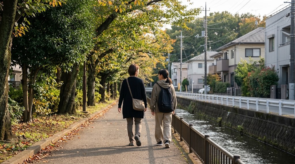 小平市の緑道を、フリースクールの見学に向かう不登校の中学生と保護者が並んで歩いている場面（イメージ）