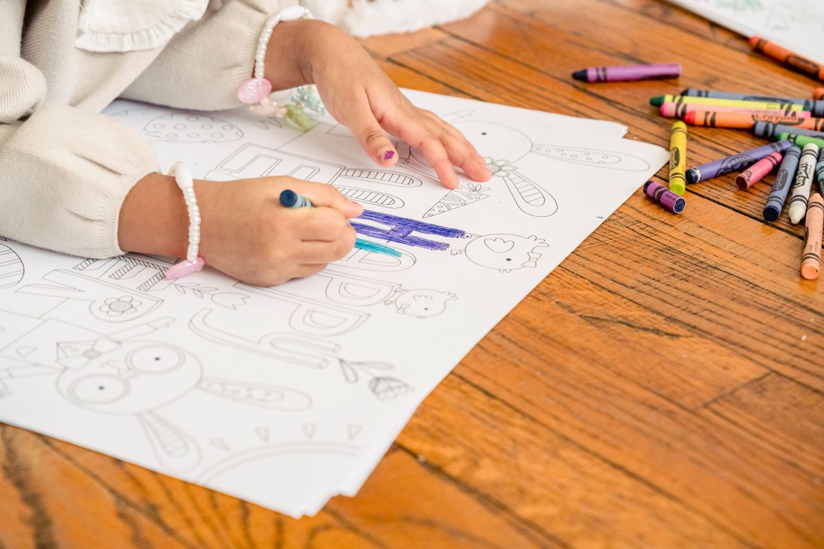 紙にペンで色をぬる子どもの手元